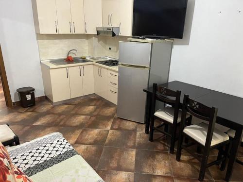Una cocina con refrigerador y una mesa y sillas. en TheCozyView1, en Lezhë