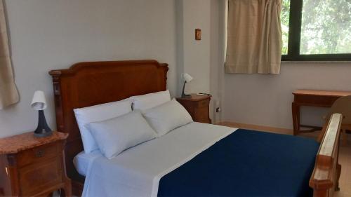 een slaapkamer met een bed met witte lakens en kussens bij CityHome in Palermo