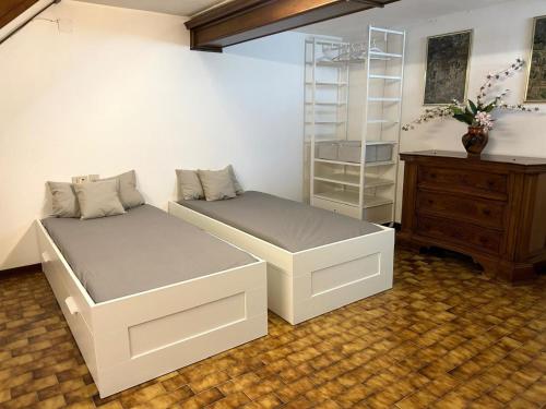 a bedroom with two beds and a desk and a dresser at Appartamento TD in Follonica