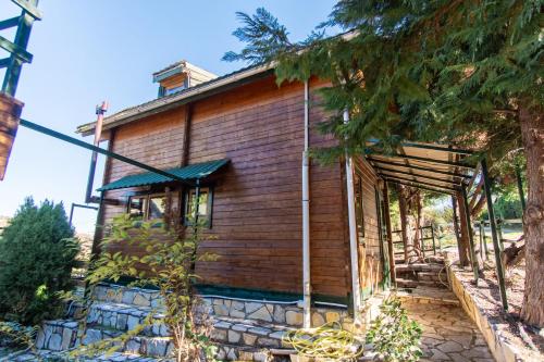 a small wooden house with a tree in front of it at Zeus-Village οικισμός φινλανδικών chalet με πισίνες & γυμναστήριο in Mólos