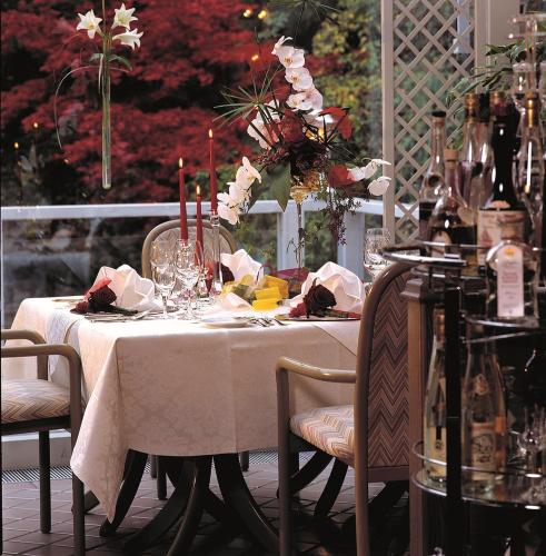 a table with a white table cloth and flowers on it at Rüters Parkhotel in Willingen