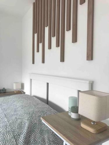 une chambre avec un lit et une table avec une lampe dans l'établissement Grand appartement en maison de ville, à Valréas