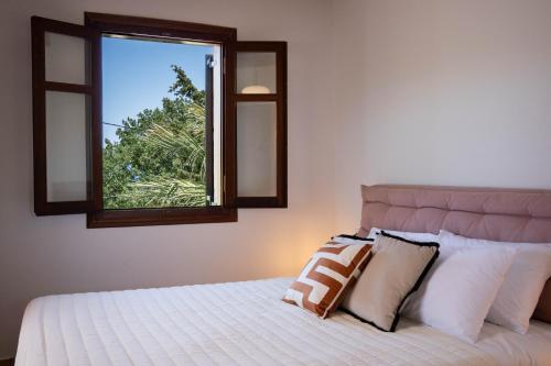 a bedroom with a large bed with a window at Aloe & Lotus Villas in Prinés