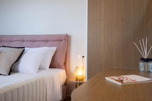 a bedroom with a bed and a table with a lamp at Aloe & Lotus Villas in Prinés