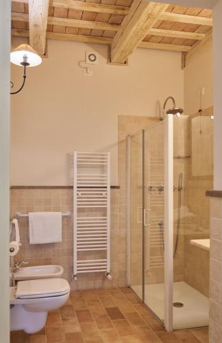 a bathroom with a toilet and a glass shower at Pamperduto Country Resort in Porto Potenza Picena