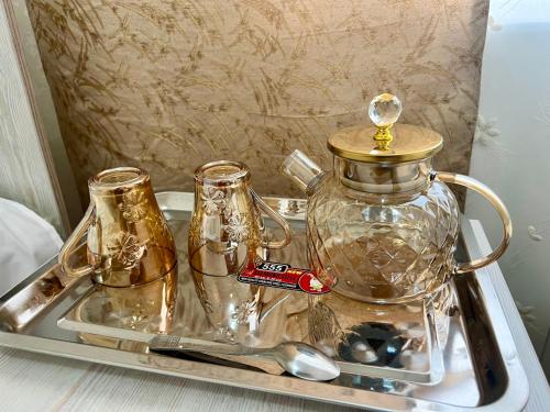 a tray with a tea kettle and glasses on it at MrShox Hostel in Samarkand