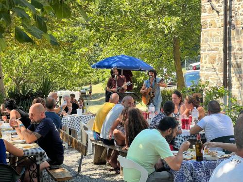 a group of people sitting at tables in a garden at Podere Badia Valdrago Agriturismo Mugello Circuit in Scarperia