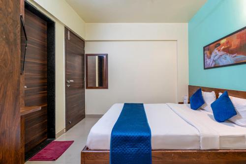 a bedroom with a large bed with blue pillows at StayBird - Icon Bliss, An Apartment Hotel, Kharadi in Pune