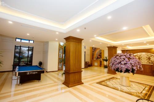 een lobby met een pooltafel en een vaas met bloemen bij Song Anh Hotel Tuần Châu in Ha Long