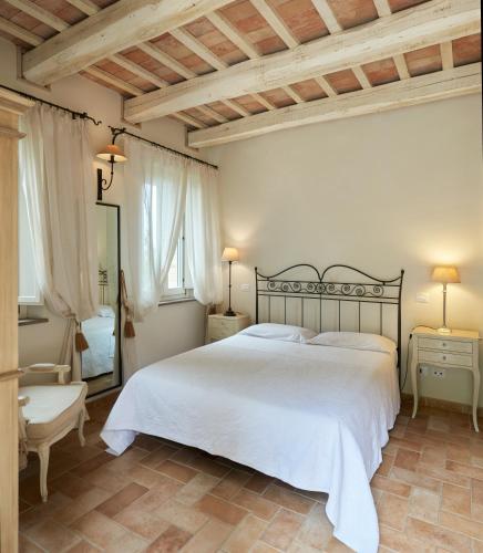 a bedroom with a large white bed and a chair at Pamperduto Country Resort in Porto Potenza Picena
