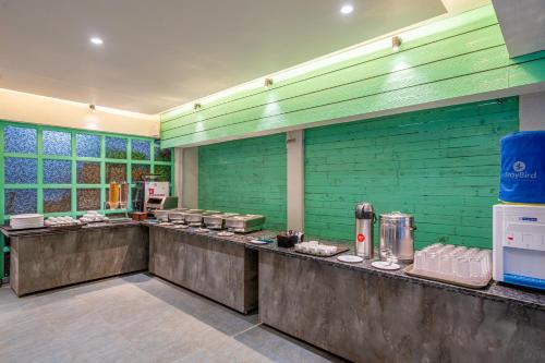 a kitchen with green walls and a counter with food at StayBird - Icon Bliss, An Apartment Hotel, Kharadi in Pune