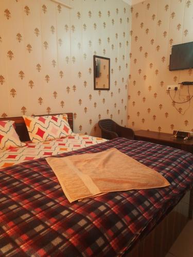 a bedroom with a bed with a blanket on it at Ganpati Villa in Dehradun
