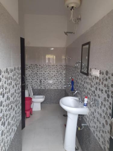 a bathroom with two toilets and a sink and a mirror at Ganpati Villa in Dehradun