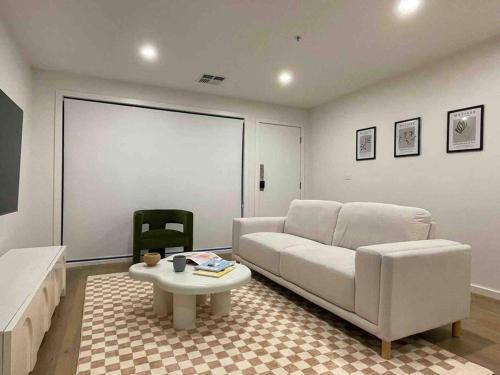 a living room with a white couch and a table at Lovely place in Bruce centre (2-bedroom-townhouse) in Belconnen