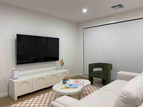 a living room with a large flat screen tv on a wall at Lovely place in Bruce centre (2-bedroom-townhouse) in Belconnen