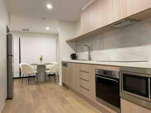 a kitchen with a table and a sink and a stove at Lovely place in Bruce centre (2-bedroom-townhouse) in Belconnen