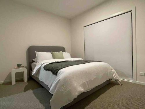 a bedroom with a large bed with a large window at Lovely place in Bruce centre (2-bedroom-townhouse) in Belconnen