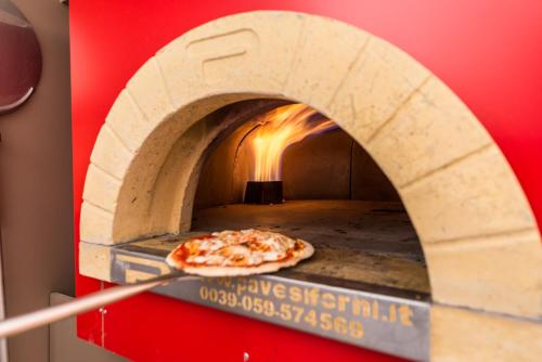 a pizza is coming out of a pizza oven at Hotel Paradiso in Sarnonico