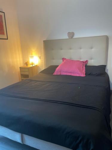 - une chambre avec un grand lit et un oreiller rose dans l'établissement Chez Olivier et Damien, à La Roche-sur-Yon