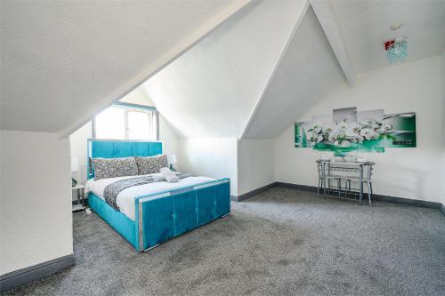 a bedroom with a blue bed and a table at *RA7H* For your relaxed & Cosy stay + Free Parking in Leeds