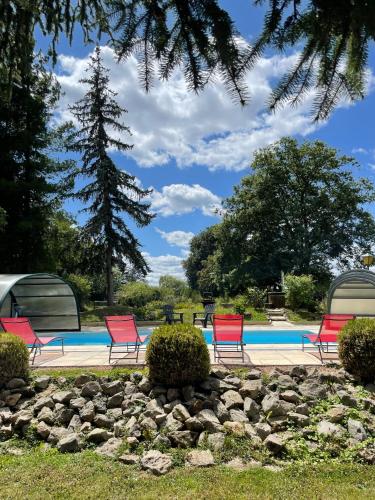 a group of red chairs by a swimming pool at Le Chalet de L'Orée du Morvan in Montberthault
