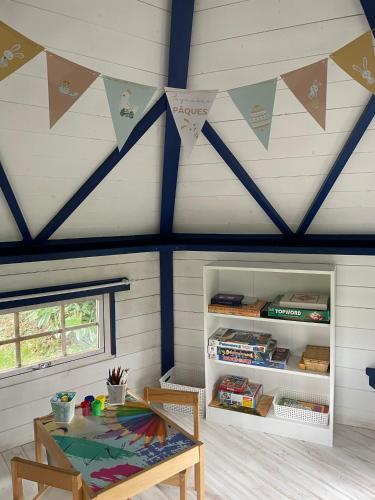 a room with a wooden table and a ceiling with flags at Le Chalet de L'Orée du Morvan in Montberthault