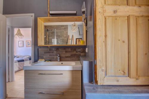 La salle de bains est pourvue d'un lavabo et d'une armoire en bois. dans l'établissement Maison vue Mer, Marseille., à Marseille