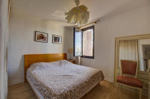 une chambre avec un lit, une fenêtre et un lustre dans l'établissement Maison vue Mer, Marseille., à Marseille