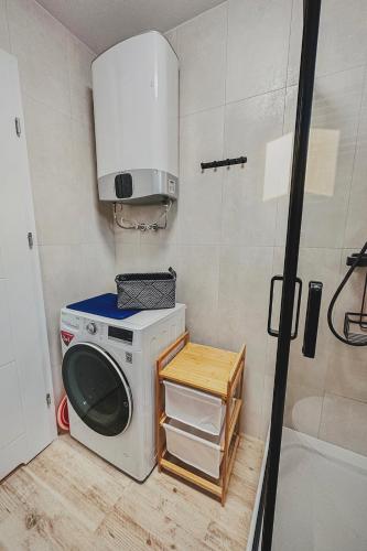 a washing machine in a bathroom with a microwave at Chce się być in Ślesin