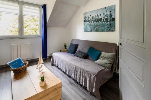 un salon avec un canapé et une fenêtre dans l'établissement Villa de la plage, à Saint-Brévin-les-Pins