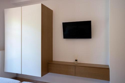 a room with a tv on a white wall at Aloe & Lotus Villas in Prinés