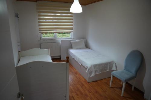 a bedroom with a bed and a chair and a window at Sevgi Konağı in Yolüstü