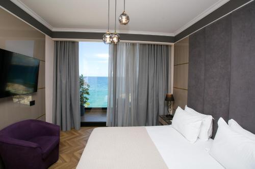 Habitación de hotel con cama y silla morada en Belvedere Hotel en Vlorë