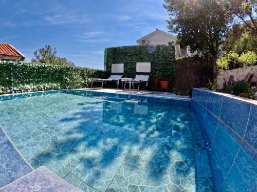 a swimming pool with two chairs sitting next to it at Apartments Obradovic in Krasici