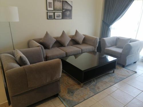 ein Wohnzimmer mit einem Sofa und einem Couchtisch in der Unterkunft Kuwait Residence in Kuwait