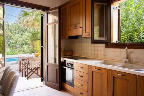 a kitchen with a sink and a patio with a table at Aloe & Lotus Villas in Prinés