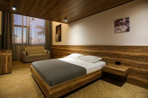 a bedroom with a bed and a chair in it at Belvedere Hotel & SPA in Vlorë