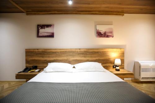 a bedroom with a large bed and a television at Belvedere Hotel & SPA in Vlorë