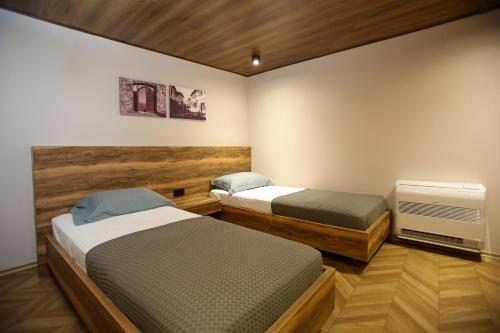 a bedroom with two beds and a tv at Belvedere Hotel & SPA in Vlorë