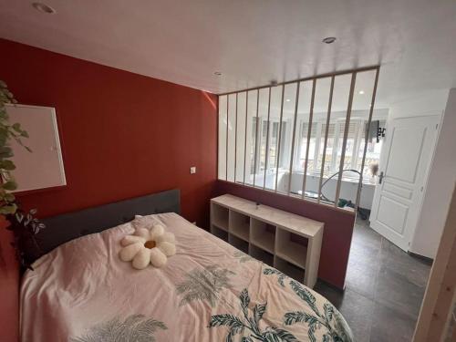 une chambre avec un lit avec une fleur dessus dans l'établissement Studio Berck , proche plage , phare , centre ville, à Berck-sur-Mer