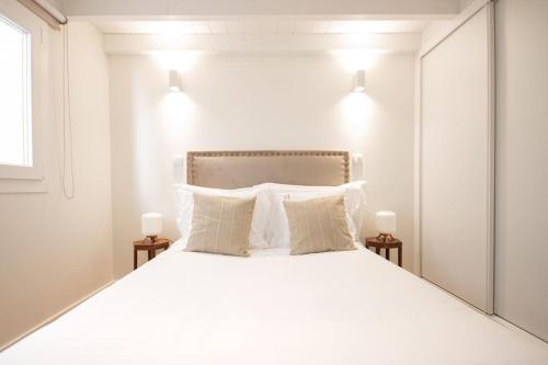 a bedroom with a large white bed with a mirror at Apartamento Porta14 2 in Chaves