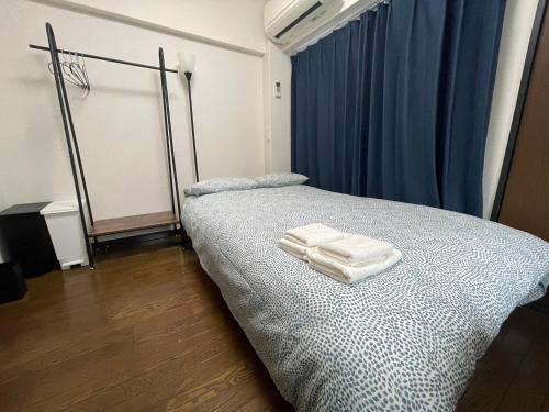 a bedroom with a bed with two towels on it at パルム天神西 in Susakiuramachi