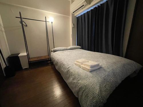 a bedroom with a bed with two towels on it at パルム天神西 in Susakiuramachi