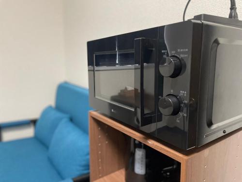 a microwave oven sitting on top of a table at パルム天神西 in Susakiuramachi