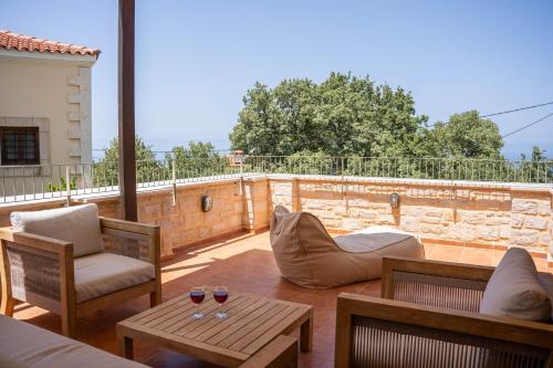 a patio with two chairs and a table with wine glasses at Aloe & Lotus Villas in Prinés