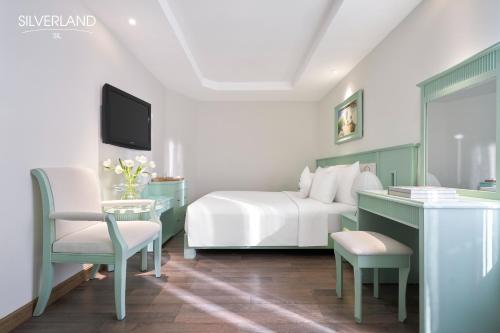 a bedroom with a bed and a desk and a tv at Silverland Sil Hotel in Ho Chi Minh City