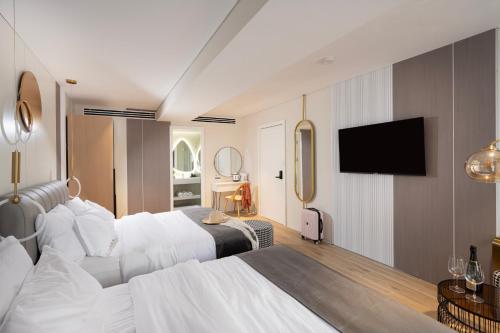 um quarto de hotel com duas camas e uma televisão de ecrã plano em Allenbeach TLV- apart Hotel- Adults only em Tel Aviv