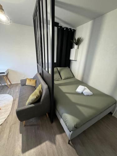 un lit et un canapé dans une chambre dans l'établissement Le Bouchon - Appartement Cosy - Wifi, à Talence