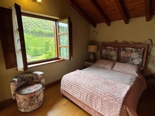 um quarto com uma cama, uma cadeira e uma janela em 5 bedrooms villa with city view private pool and enclosed garden at Bizkaia em Emaldia