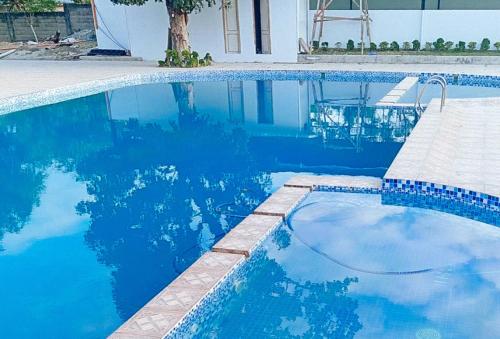 a swimming pool with blue water in front of a house at McKinley Grand Marina Hotel and Resort in Isabela